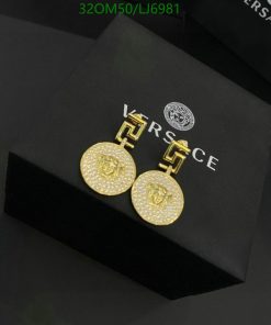 Gold Versace medallion earrings on black box.