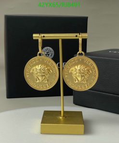 Gold coin-shaped earrings on display stand.