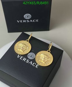 Gold medallion earrings on designer box.