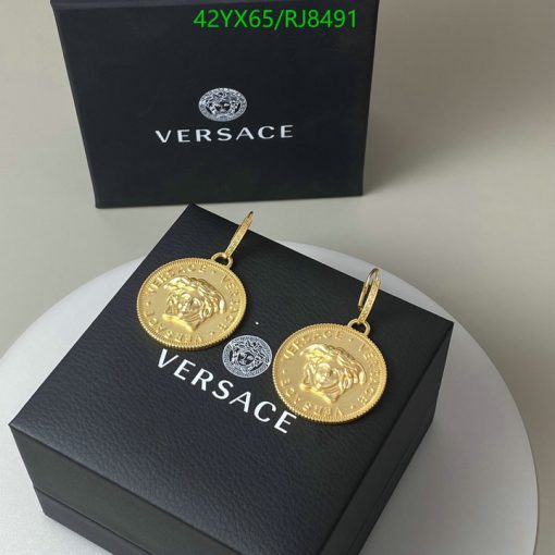 Gold medallion earrings on designer box.