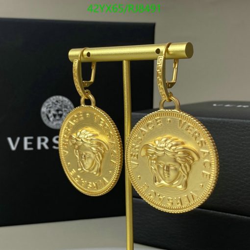 Gold Versace medallion earrings on display.