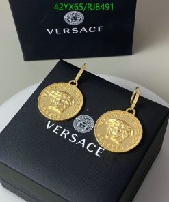 Versace branded gold medallion earrings on black box.