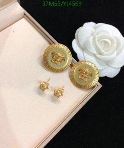 Gold lion earrings with white flower decoration.