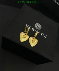 Gold heart-shaped earrings on black background.