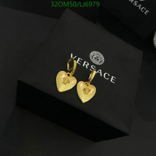 Gold heart-shaped earrings on black background.