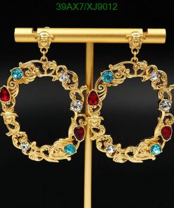 Gold earrings with gemstones on black background.