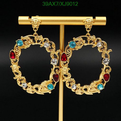 Gold earrings with gemstones on black background.