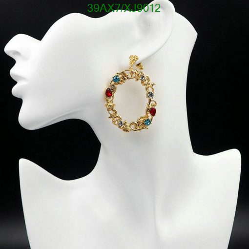 Gold earring with multicolored stones on mannequin.