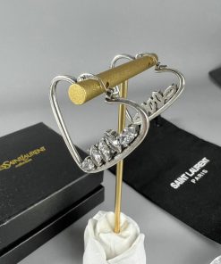 Diamond-encrusted heart earring with brand packaging.