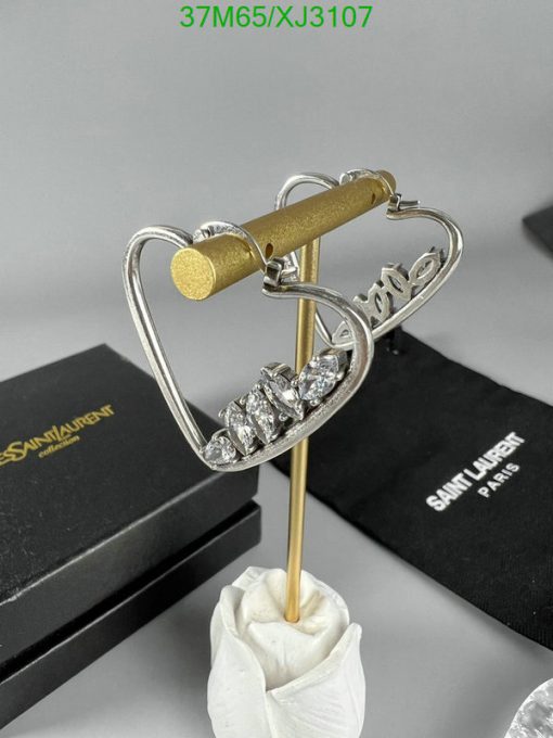 Diamond-encrusted heart earring with brand packaging.