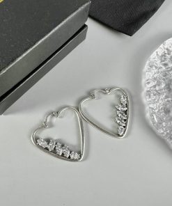 Heart-shaped silver earrings with crystals.