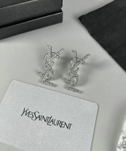 Designer logo earrings with sparkling stones on display.