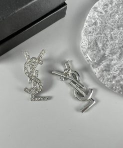 Designer logo pendant and earrings set on table.