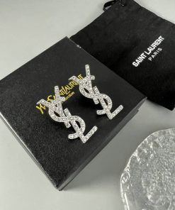 Designer logo earrings with packaging on table.