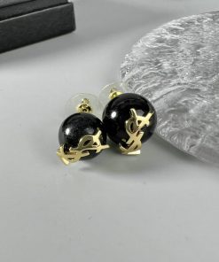 Designer black and gold round earrings on display.