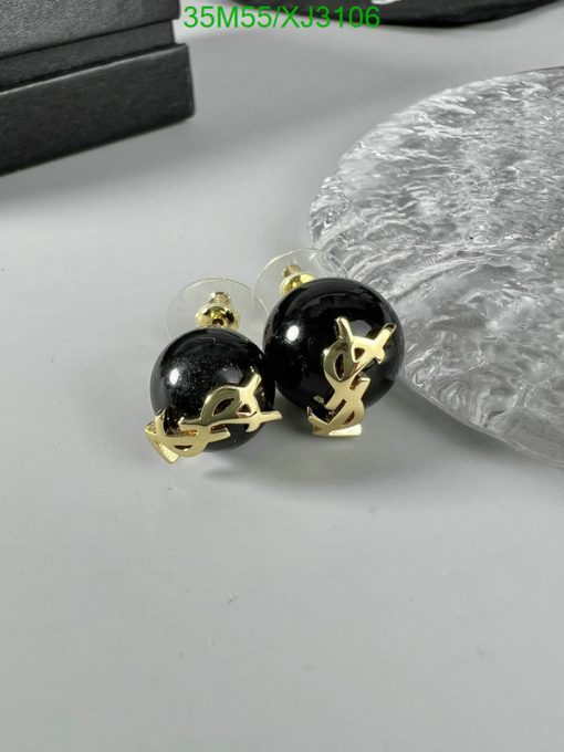 Designer black and gold round earrings on display.