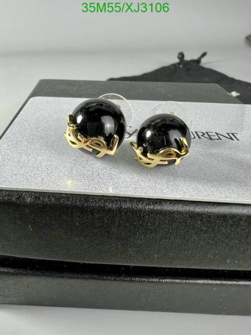 Black and gold earrings on display stand.