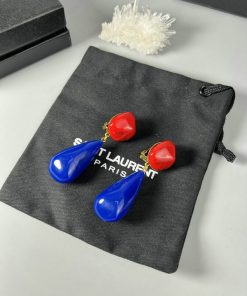 Blue and red drop earrings on designer pouch.