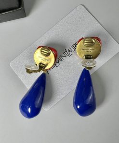 Blue teardrop earrings on branded card.