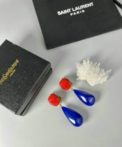 Red and blue Yves Saint Laurent earrings with boxes.