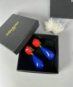 Red and blue earrings in black jewelry box.