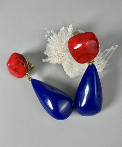 Red and blue drop earrings on white background.