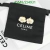 Gold floral earrings on Celine Paris black pouch.