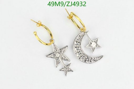 Star and moon diamond earrings on white.