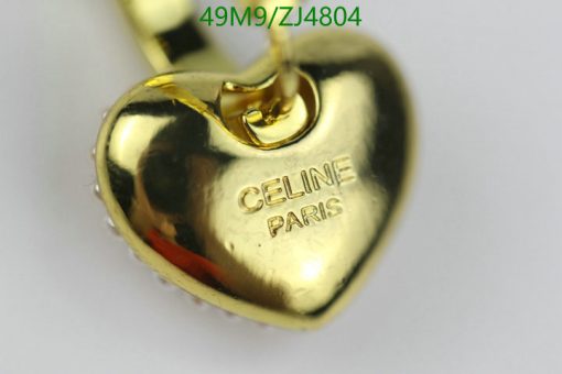 Gold heart-shaped pendant with engraving on white background.