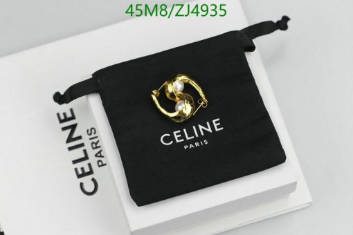 Gold earring on Celine Paris branded pouch.