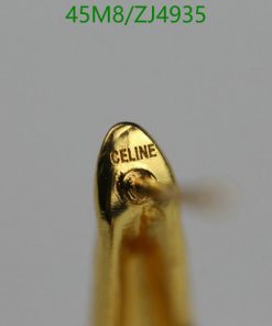 Close-up of golden object with "CELINE" engraving.