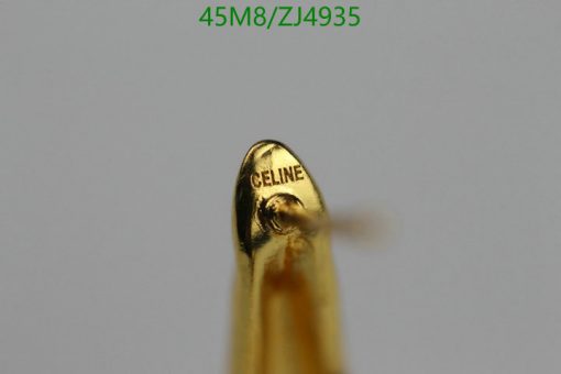 Close-up of golden object with "CELINE" engraving.