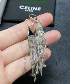 Silver tassel earrings held in hand.