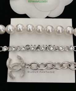 Pearl necklace, diamond bracelet, silver bow brooch display.