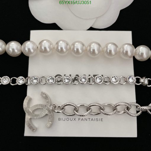 Pearl necklace, diamond bracelet, silver bow brooch display.