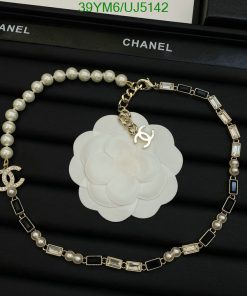 Chanel pearl necklace and flower brooch on display.