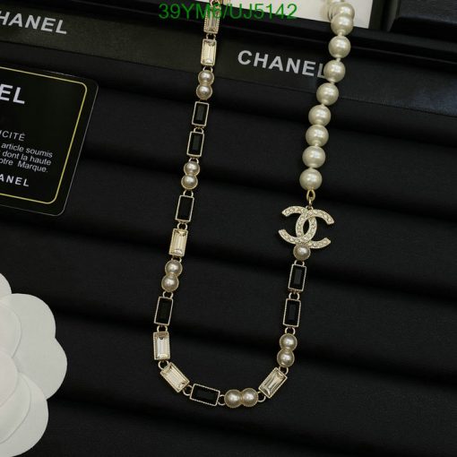 Chanel pearl necklace with logo pendant on display.