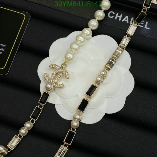 Pearl necklace with logo pendant on white flower.