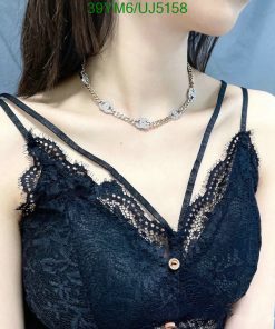 Woman in lace top with silver necklace.