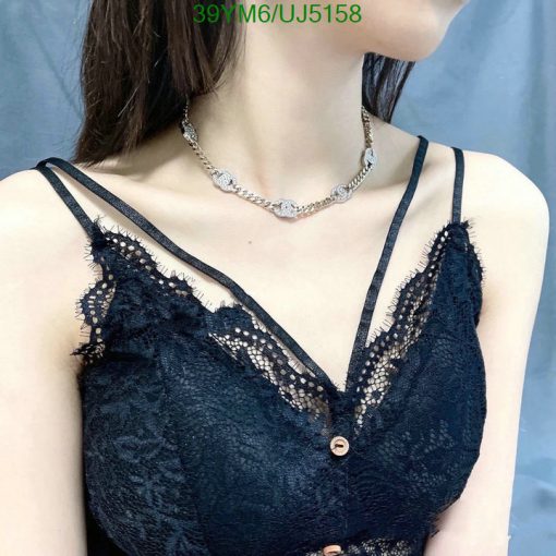 Woman in lace top with silver necklace.