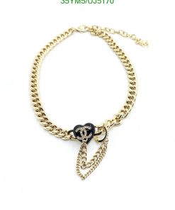 Gold chain bracelet with black charm and pendant.