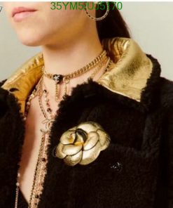 Woman wearing vintage jacket and gold jewelry.