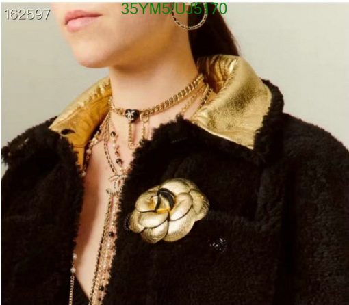 Woman wearing vintage jacket and gold jewelry.