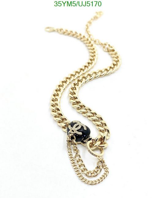 Gold chain necklace with pendant on white background.