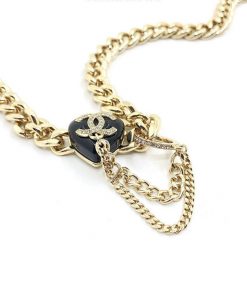 Gold chain necklace with black pendant and anchor detail.