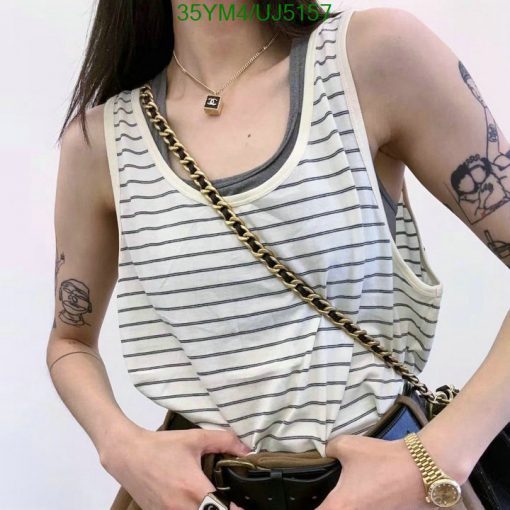 Woman in striped tank top with shoulder bag and tattoos.