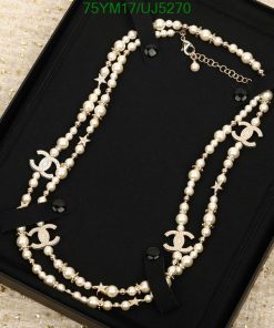 Elegant pearl necklace with gold accents on black display.