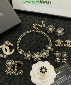 Chanel jewelry collection with flowers and logo on display.