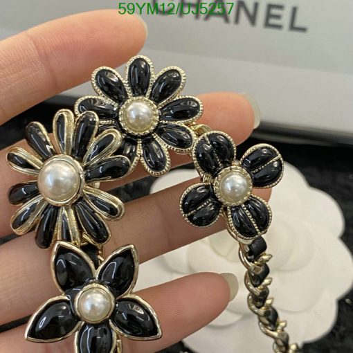 Hand holding black flower pearl earrings.