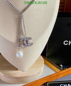 Chanel necklace with logo and pearl on display stand.